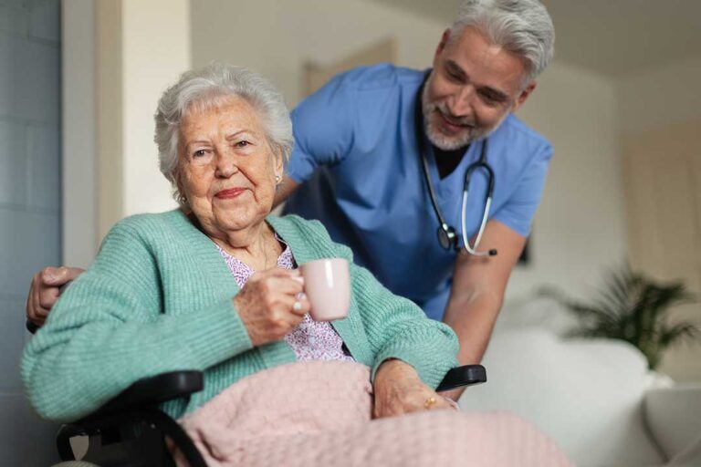 An adult child gently holding hands with an elderly parent at a small dining table in a cozy home.